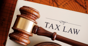 A wooden judge’s gavel rests on a document labeled “Tax Law,” symbolizing the importance of legal and tax expertise in financial decision-making for veterinary practices.